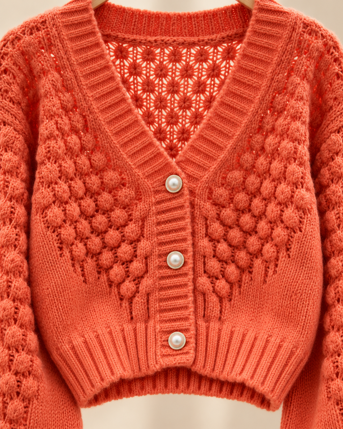 Detalhe da malha e botões do cardigan laranja